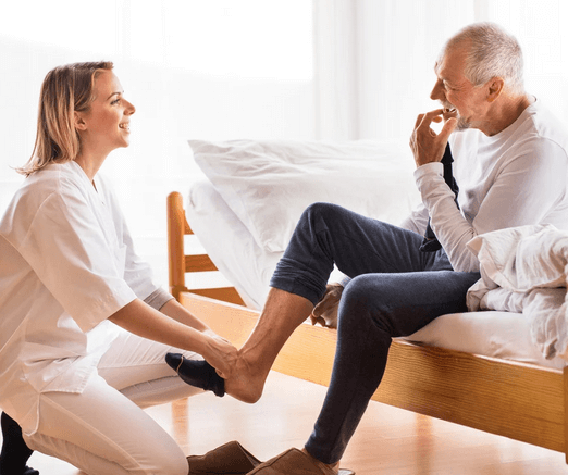 A woman puts on a biabetic man's sock