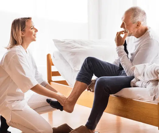 A woman puts on a biabetic man's sock
