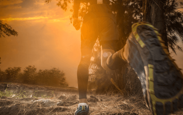 Person trail running in blister-free trail running socks at sunset