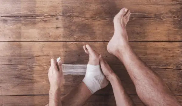 a person wrapping their foot to prevent blisters