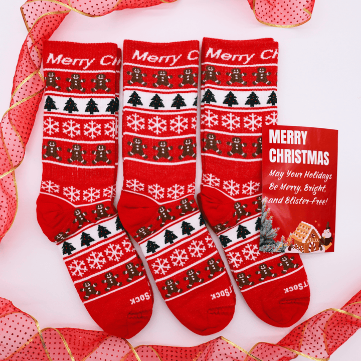 Set of red Explore Crew Christmas-themed socks with a small card on a decorative background