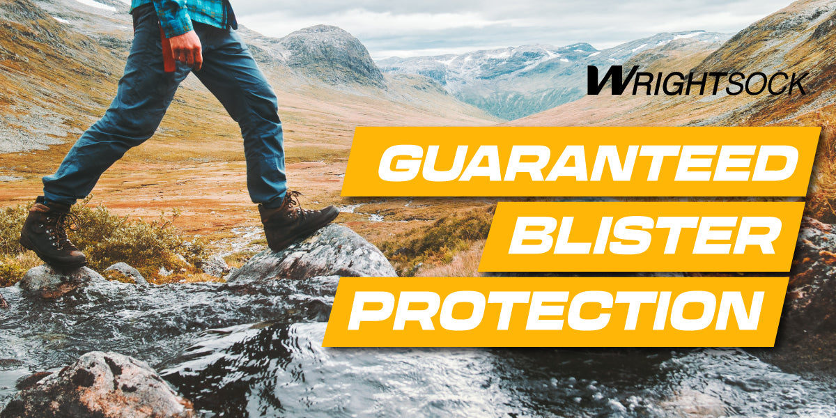 A person walking on stones over a river. Wrightsock slide: Guaranteed Blister Protection.